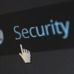 extreme close up of computer screen with hand cursor pointing at security